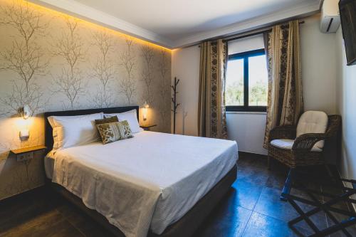 夫塞塔Vila Fuzeta Bed & Breakfast的卧室配有床、椅子和窗户。