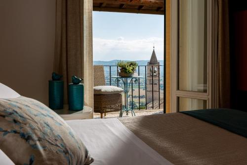 阿西西伊迪雅尔酒店的一间卧室设有一张床,享有阳台的景色