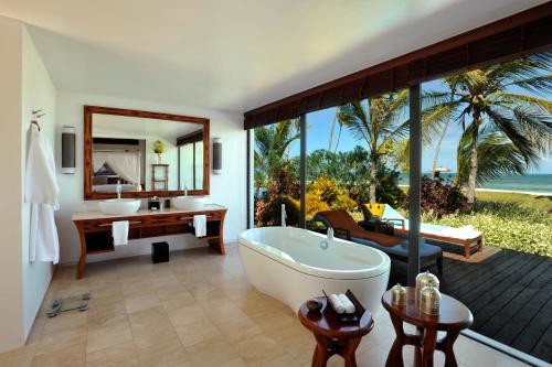 基济姆卡济桑给巴尔住宅酒店的带浴缸和盥洗盆的浴室以及书桌。