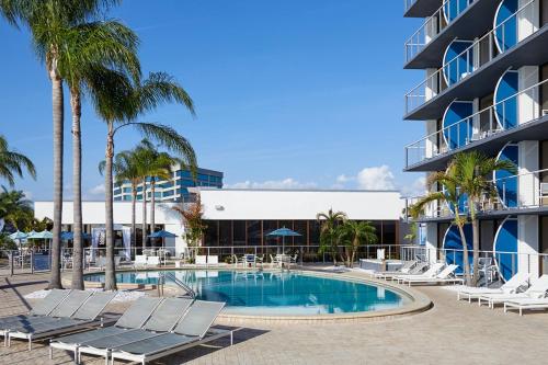 坦帕戈弗雷酒店及卡巴纳斯坦帕的一座游泳池位于酒店前方,设有椅子和一座建筑