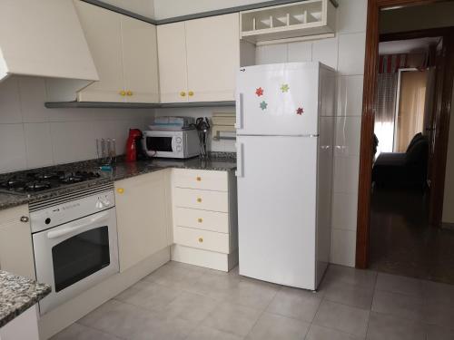 卡斯特利翁-德拉普拉纳Apartamento la luna的厨房配有白色家电和白色冰箱