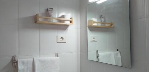 卡里涅纳Hostal Meson de Paco的浴室提供镜子和白色毛巾