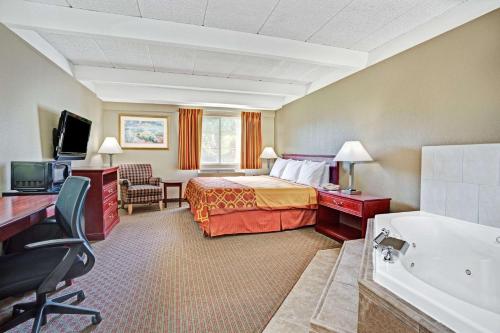 爱荷华爱荷华市特维乐兹酒店的酒店客房配有一张床和浴缸。