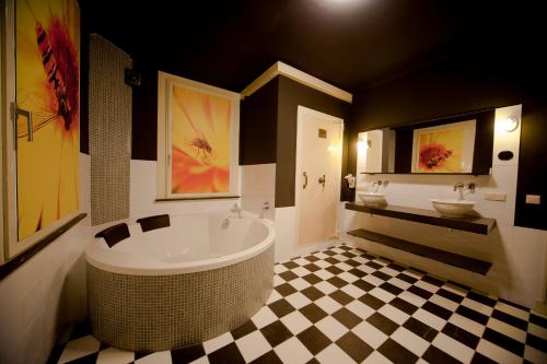 Heeswijk-DintherRaadhuis Dinther Suites的一间带大浴缸和水槽的浴室