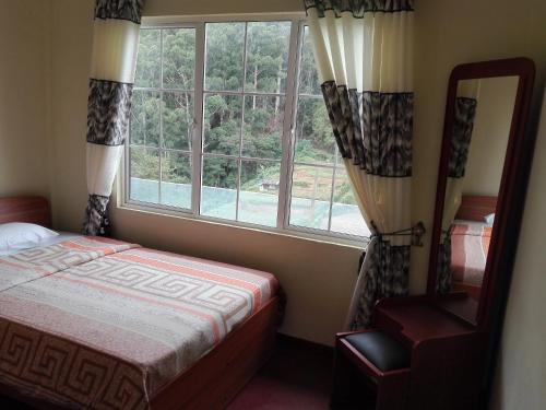 努沃勒埃利耶Keshiya Holiday Home的一间卧室设有一张床和一个大窗户