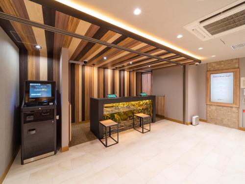 西条市Super Hotel Iyo Saijo的大房间设有鱼缸和电视