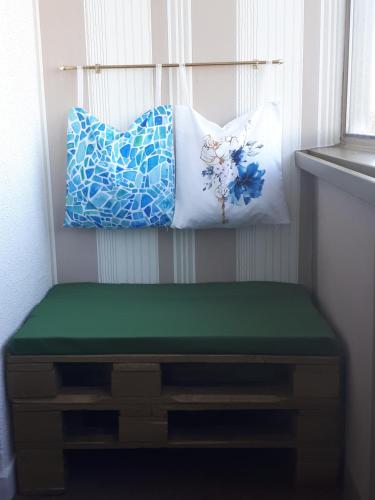 武科瓦尔Apartman Panorama的带绿色靠垫和2个枕头的长凳