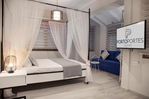 尼坡帝PORTO PORTES suites的一间卧室配有天蓬床和蓝色的沙发