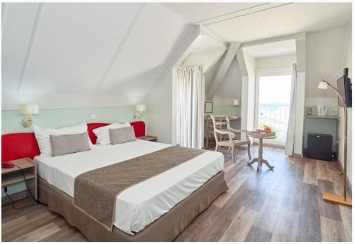 圣丹尼斯奥斯特拉尔酒店的一间卧室配有一张大床和一张桌子及椅子