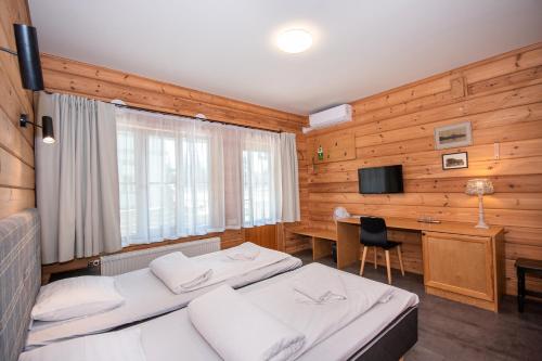 派尔努Kurgo Villa self check-in hotel的一间卧室配有两张床、一张桌子和一台电视。