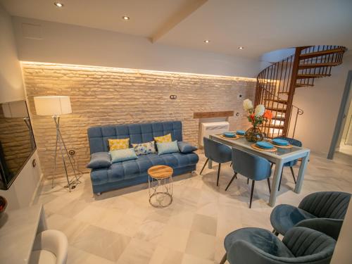 塞维利亚Casas de Sevilla - Apartamentos Vidrio 7的客厅配有蓝色的沙发和桌子