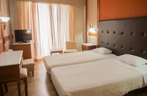 沃洛斯帕克酒店的酒店客房设有两张床和电视。