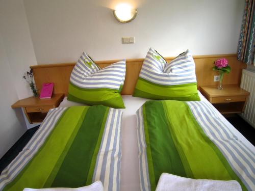 瓦格赖恩塞瓦尔德公寓的一间卧室配有两张带绿色和白色床单的床