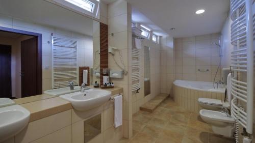 久洛久洛健康酒店的一间带两个水槽、一个浴缸和两个卫生间的浴室