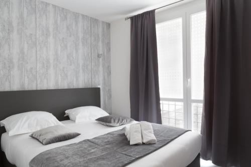 里尔里尔城市酒店的卧室配有带枕头的床铺和窗户。