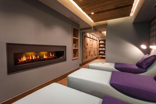 诺德奈Hotel Restaurant Ennen的客厅设有壁炉和紫色椅子