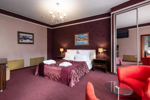 布克维Bukovel Apart的酒店客房,配有一张床和一张红色椅子