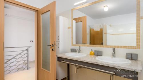 乌马格Rona apartment Denis的一间带两个盥洗盆和大镜子的浴室