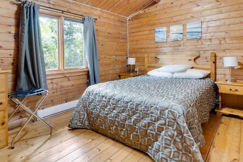 英戈尼什海滩Ingonish Chalets的小木屋内一间卧室,配有一张床