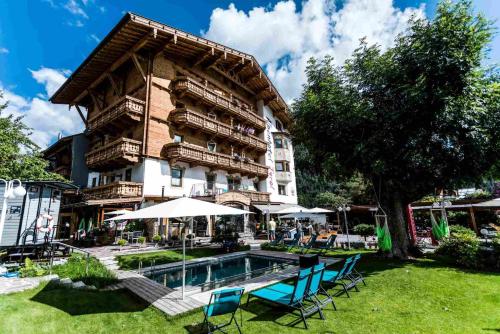 佩尔蒂绍Alpenhotel Tyrol - Konzepthotel - adults only的大楼前设有游泳池的酒店
