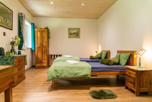 雄济耶Sanskriti的一间卧室配有两张带绿色枕头的床