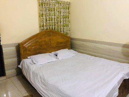 吉大港Hotel Regal Palace的卧室内的一张带木制床头板的床