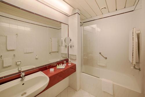 安科纳NH安科纳酒店的一间带水槽、浴缸和镜子的浴室