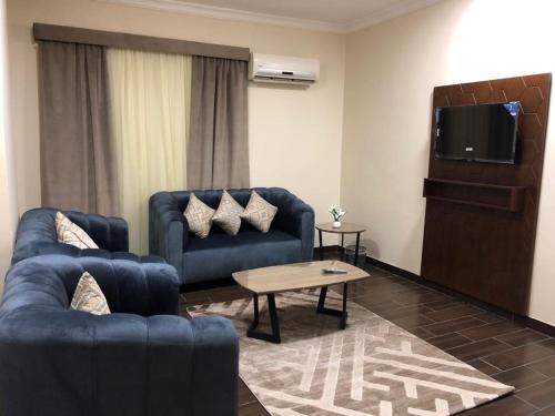 麦地那هبي نيس للوحدات السكنية的客厅配有2张蓝色沙发和电视