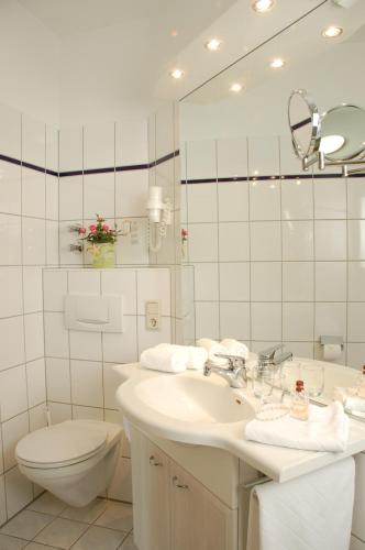 莱尔特Landhotel Behre的一间带水槽、卫生间和镜子的浴室