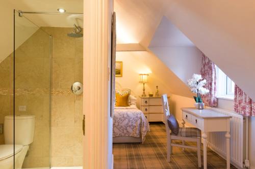 沃克沃斯Warkworth House Hotel的带淋浴和床的阁楼浴室