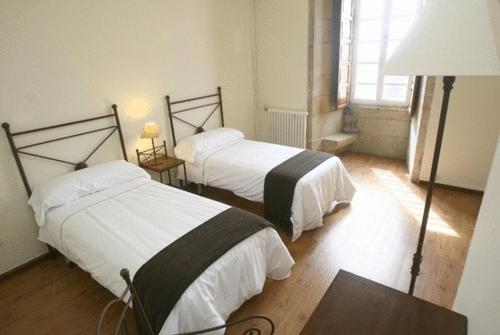 圣地亚哥－德孔波斯特拉圣马丁皮娜里奥豪斯佩德里亚酒店的一间卧室配有两张床、一张桌子和一盏灯。