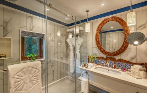 坎多林泰姬陵度假村及商老庄乡，果阿的带淋浴、盥洗盆和镜子的浴室