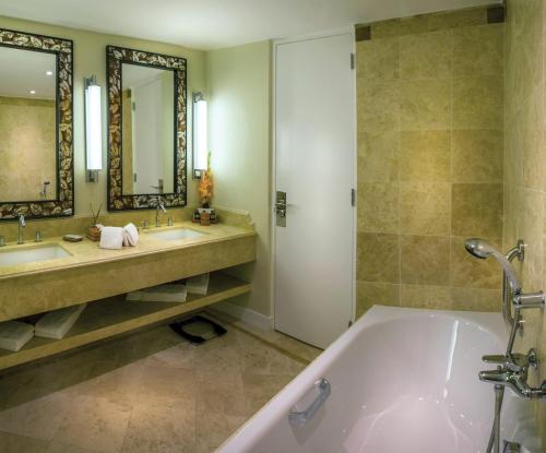 马丘比丘Sanctuary Lodge, A Belmond Hotel, Machu Picchu的带浴缸、两个盥洗盆和淋浴的浴室。