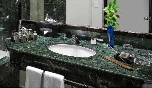 坎昆坎昆绿洲全包式酒店的浴室设有黑色大理石台面和水槽
