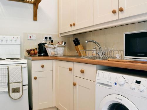 阿伯加文尼Ty-Gwyn的厨房配有水槽和洗衣机