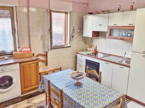 贾迪尼-纳克索斯玛丽亚焦万娜公寓的厨房配有桌子、桌子和水槽