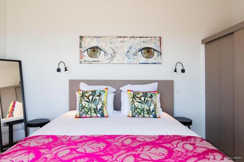 莱特鲁瓦西莱Appart Bleu Caraibe Bord de Mer Breakfast PROMO sur wwwvacancesenmartiniquecom的一间卧室配有一张大床和粉红色的床罩