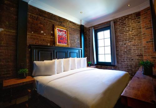 纽约苏豪酒店的砖墙客房内的一张大床