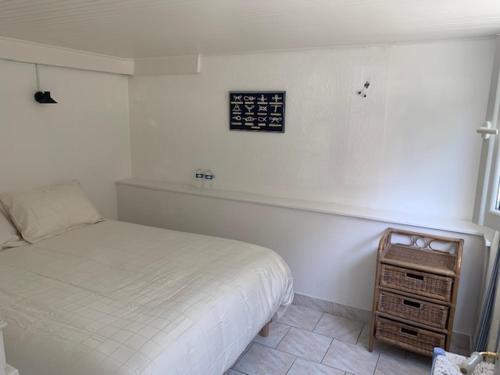 滨海圣洛朗INTERLUDE omaha beach 50 m de la plage的卧室配有一张床,墙上挂着一个钟