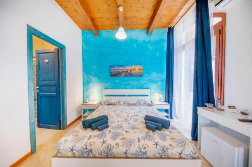切法卢Borgo Marino Suite B&B的一间卧室配有一张带蓝色墙壁的大床