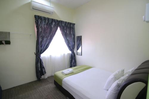 巴力拉惹Homestay Hj Esmon 3 UTHM Parit Raja的一间卧室设有一张床和一个窗口