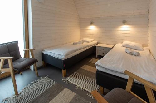 基维厄利Tuhamäe hosteli puhkemaja的一间设有两张床、一张沙发和一把椅子的房间