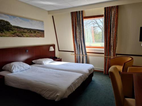 宁斯佩特弗莱彻酒店的酒店客房设有两张床和窗户。