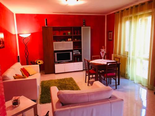 LettomanoppelloCASA MAJA casa per vacanze abruzzo的客厅设有红色的墙壁和桌子