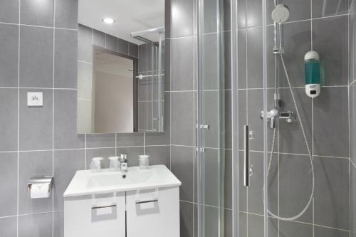 里尔里尔城市酒店的带淋浴和盥洗盆的浴室