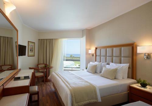 法里拉基阿波罗海滩酒店的一间设有大床和窗户的酒店客房