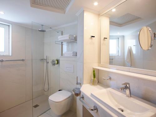法里拉基阿波罗海滩酒店的浴室配有卫生间、盥洗盆和淋浴。
