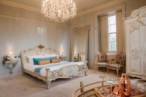 查希尔Newton Hall的一间卧室配有一张大床和一个吊灯。