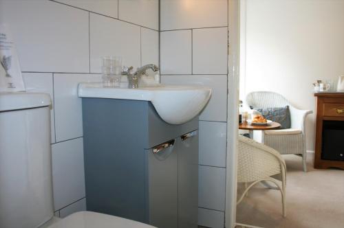 温德米尔马车房客栈的白色的浴室设有水槽和水槽