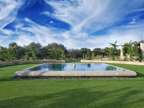 塞哥维亚Hotel Caserio Aldeallana的草地上的一个大型游泳池,天空